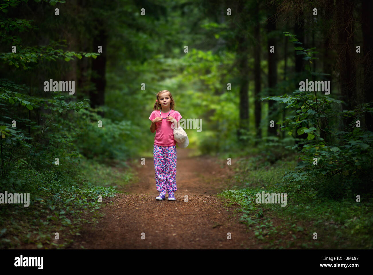 Ragazza in piedi sul sentiero nel bosco Foto Stock