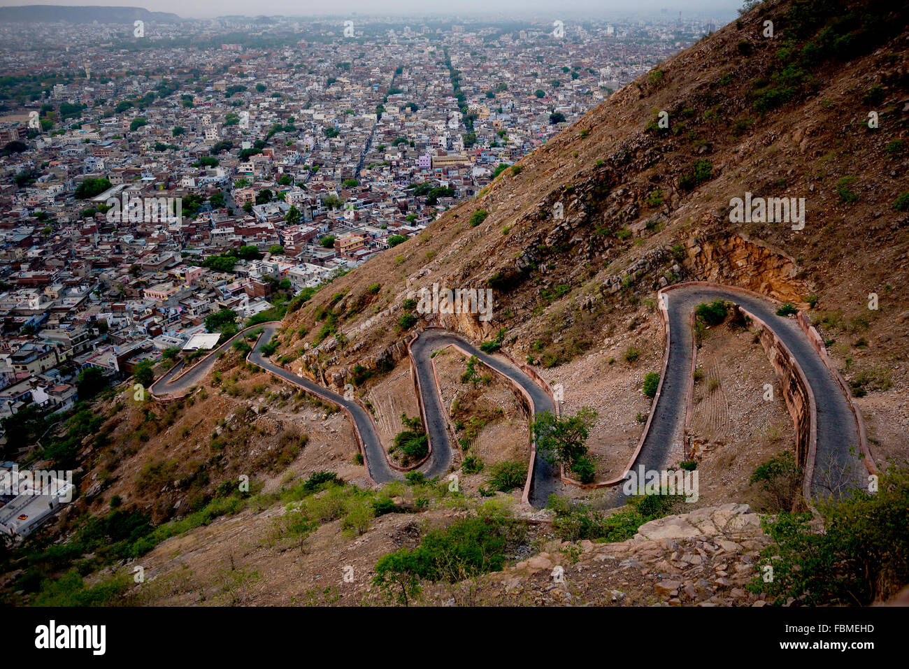 Una strada di switchback e città di Jaipur visto da Tiger Fort, Rajasthan, India Foto Stock