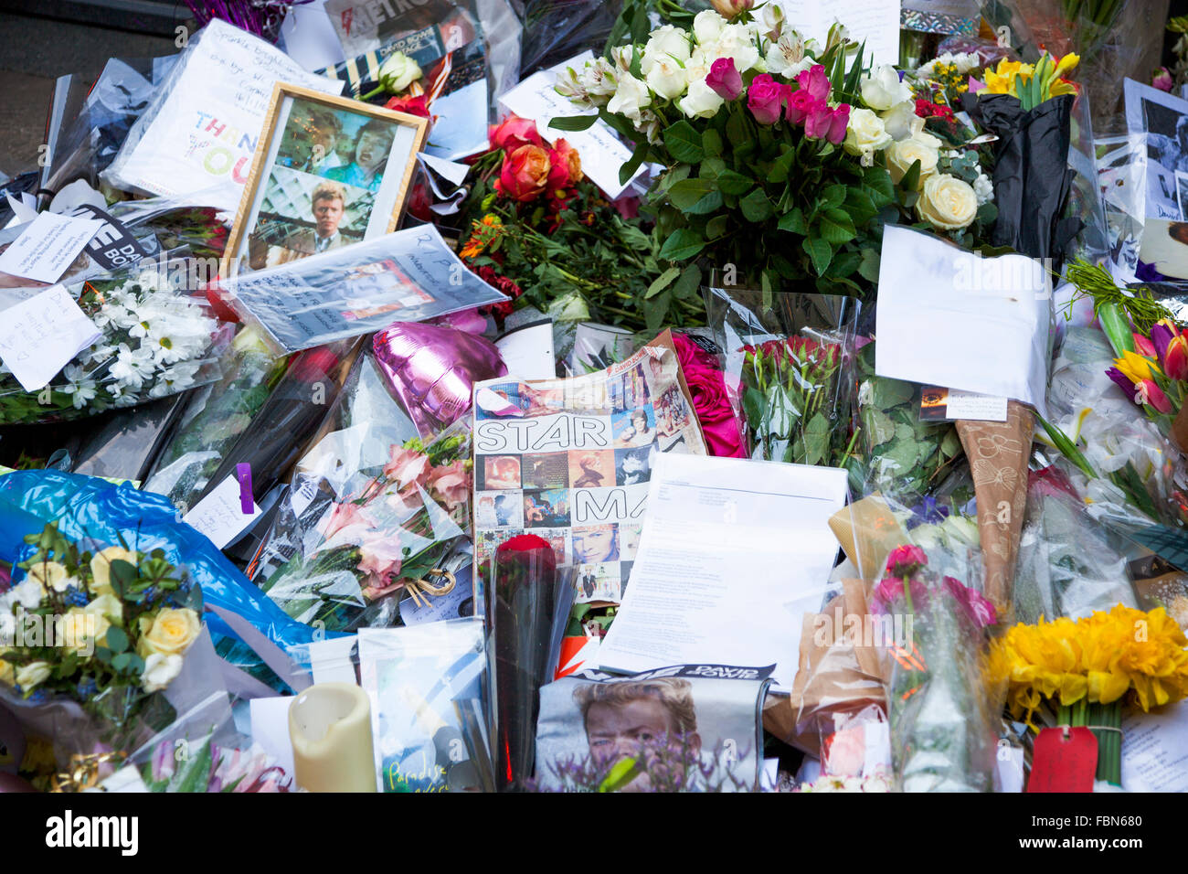 Londra, Regno Unito. 18 gennaio 2015. Appassionati di fiori di laici e di lasciare messaggi sul Heddon Street dopo la improvvisa scomparsa del musicista e attore David Bowie il 10 gennaio. Il santuario segna la posizione del coperchio fotografia di Bowie album 1972 l'aumento e la caduta di Ziggy Stardust. Credito: Nathaniel Noir/Alamy Live News Foto Stock