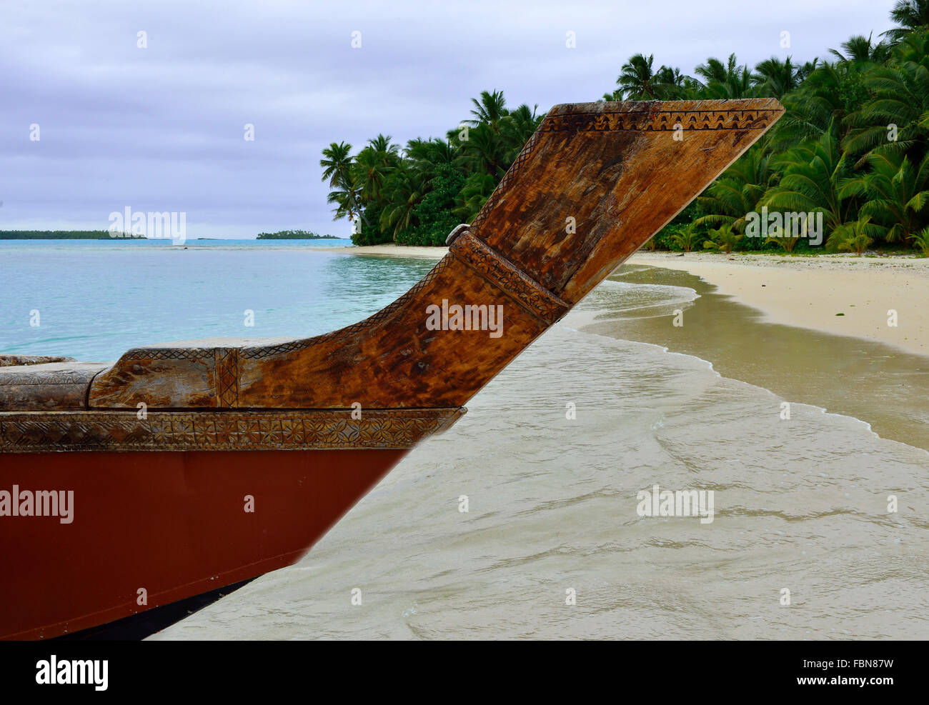 Prow di una tradizionale barca polinesiana in legno o Vaka sulla spiaggia e la laguna di tropicale un piede Isola, Aitutaki, Isole Cook Foto Stock
