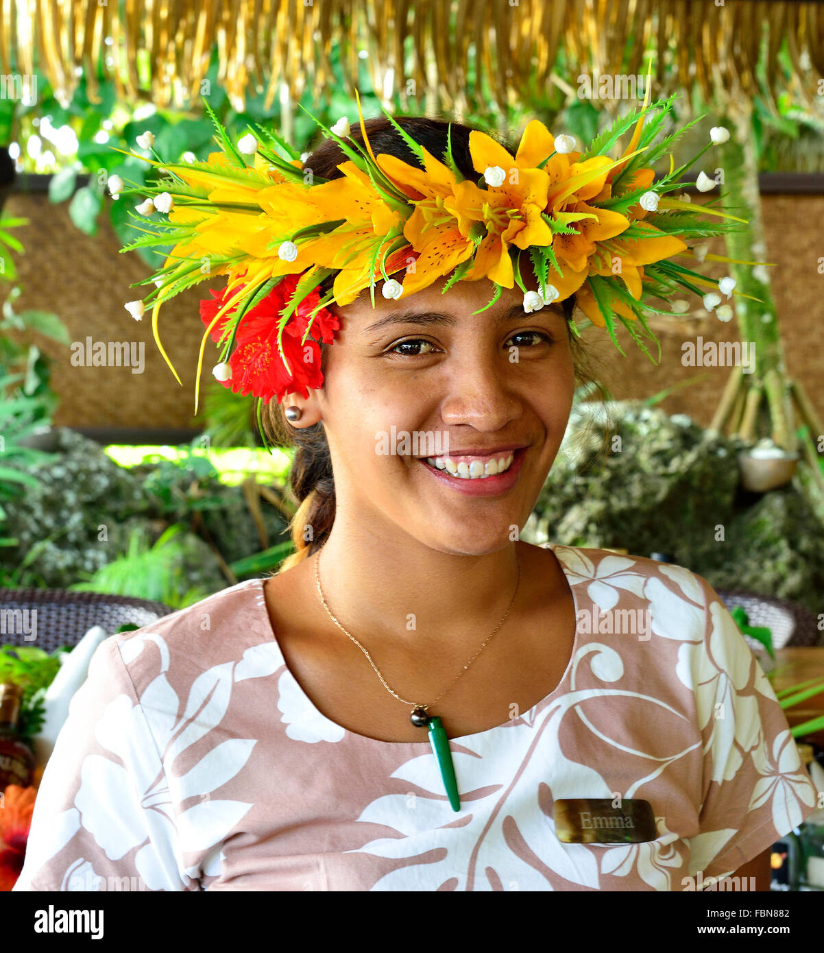 Bella Cook Island Polinesiana sorridente ragazza con un tradizionale headdress di fiori gialli sull'isola del Sud Pacifico di Aitutaki, Isole Cook Foto Stock