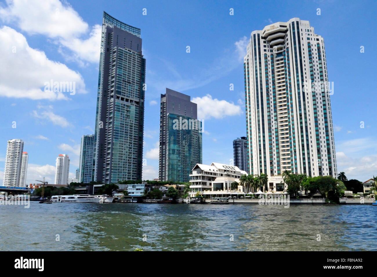 Il fiume Chao Phraya e il moderno skyline di Bangkok, Bangrak district, Bangkok, Thailandia, Sud Est asiatico Foto Stock