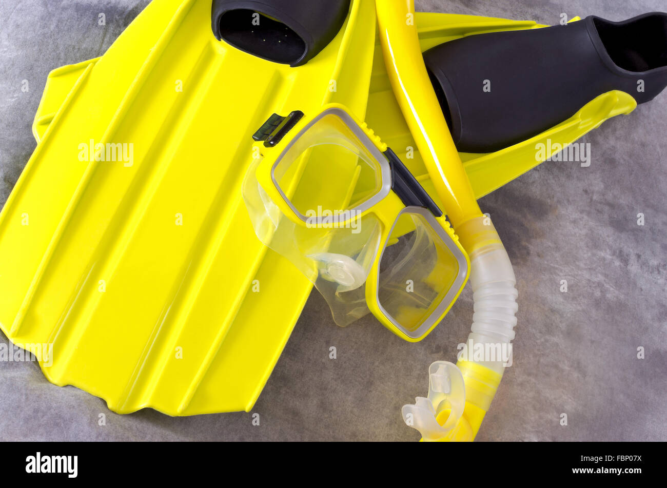 Giallo snorkeling maschera e pinne snorkeling attrezzi isolati contro uno sfondo grigio Foto Stock