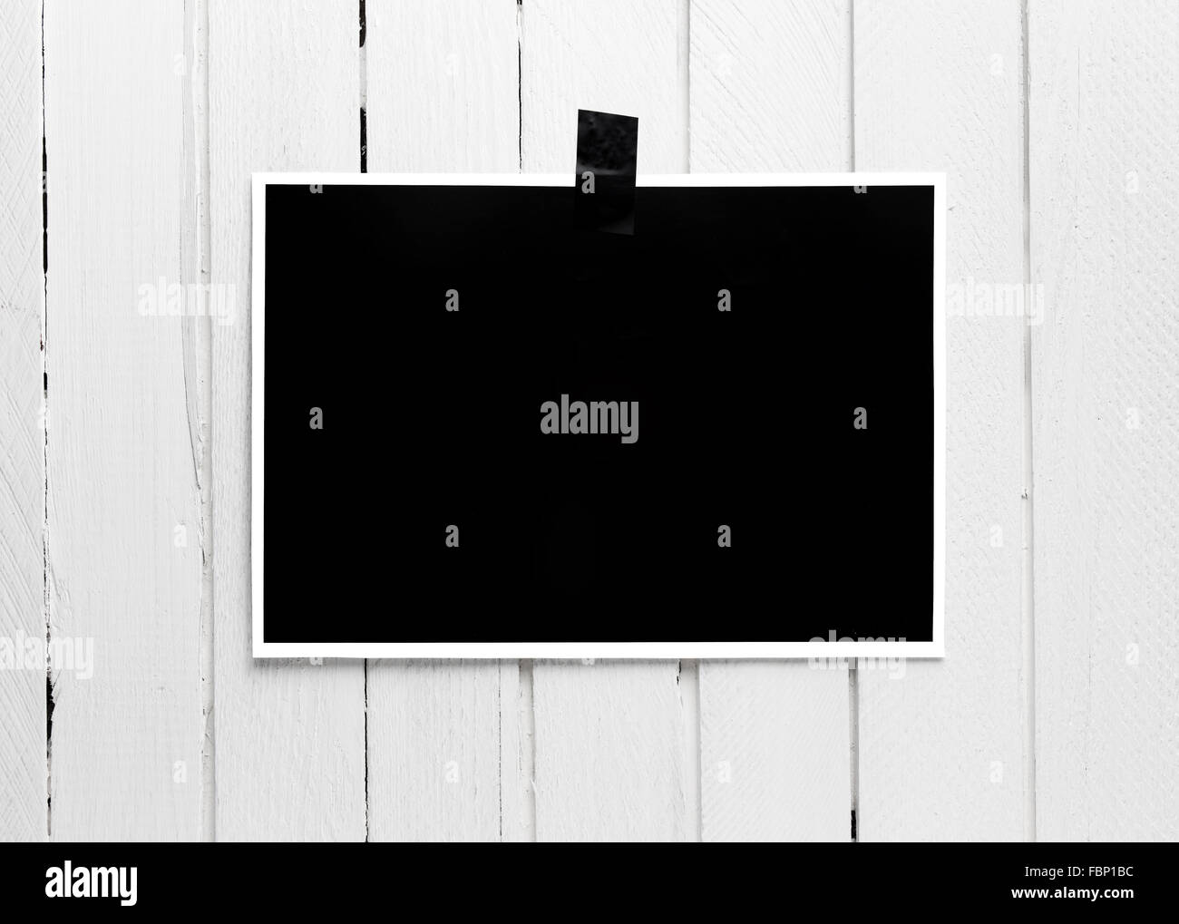 Nero Bianco poster appeso su un nastro bianco sul tavolato in legno parete. Foto Stock