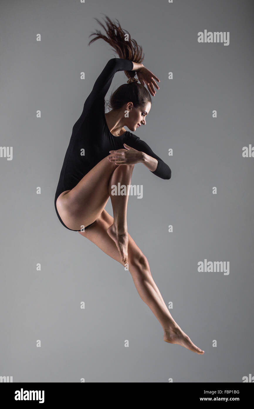 La ballerina indossa sport corpo è il salto in verticale Foto Stock