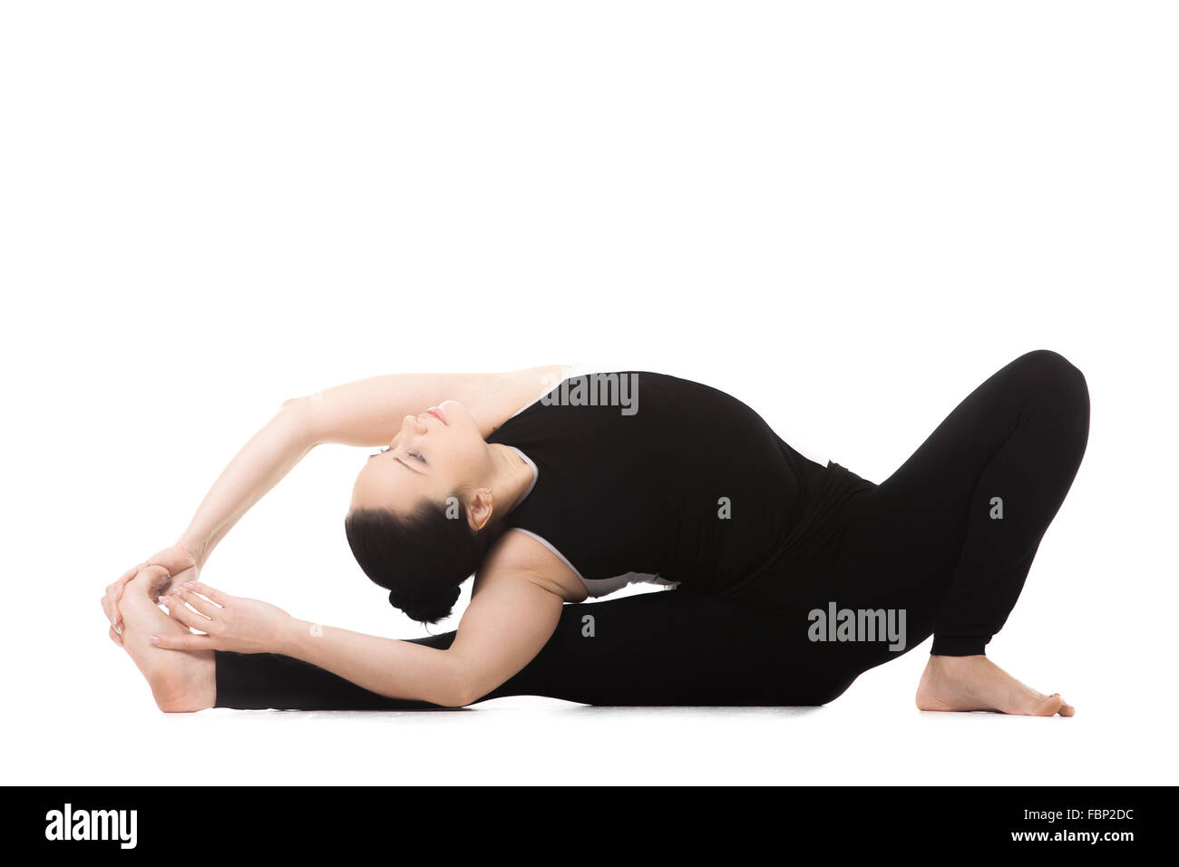 Yoga sportivo girl su sfondo bianco facendo allenamento fitness, asana Janu Sirshasana, testa a ginocchio piegare in avanti pone Foto Stock
