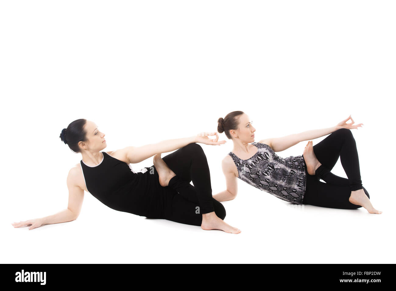 Sporty yogi partner femmina facendo asana insieme, fitness training, la pratica dello yoga con il partner, il rilassamento in dandasana Yoga Foto Stock