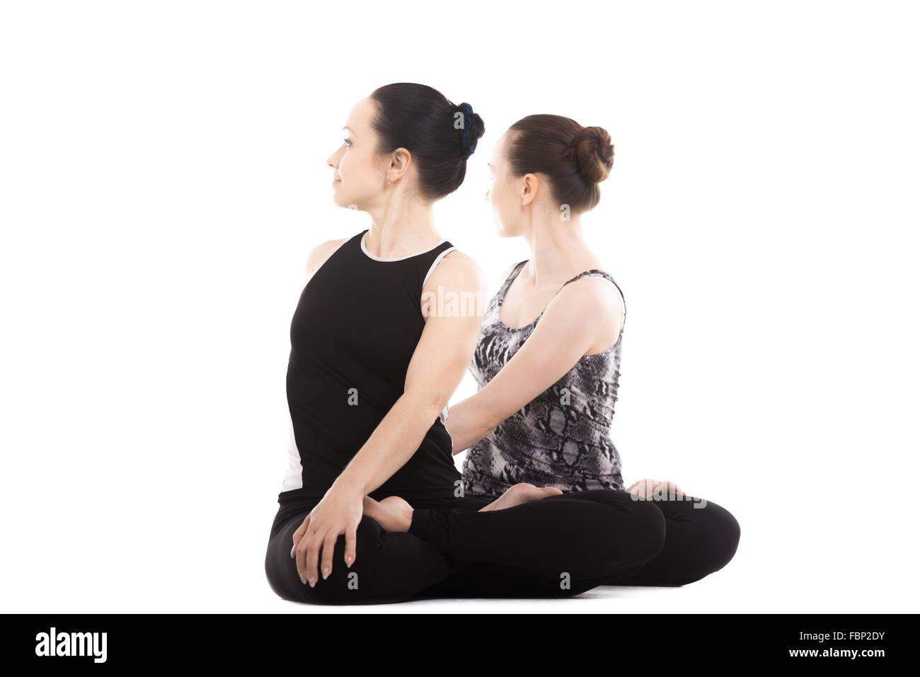 Sporty yogi partner femmina facendo asana insieme, fitness training, la pratica dello yoga con il partner, soggiorno rilassante in posa Foto Stock
