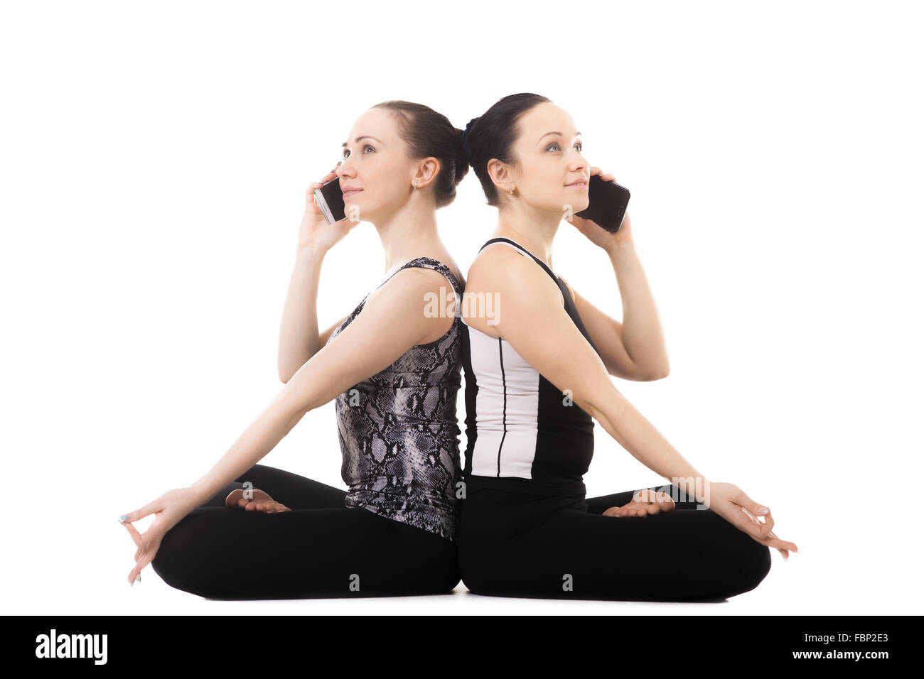 Bella yogi sportivo partner femmina facendo fitness training insieme, la pratica dello yoga con il partner, sedersi pongono Padmasana, Lotus Foto Stock