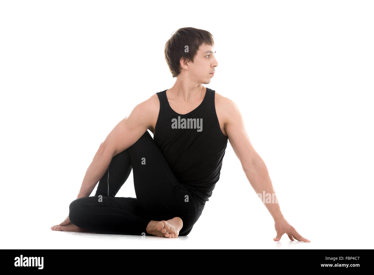 Sporty attraente giovane uomo che lavora fuori, siting in metà signore dei pesci pongono, Ardha Matsyendrasana, terapeutico per il digestivo Foto Stock