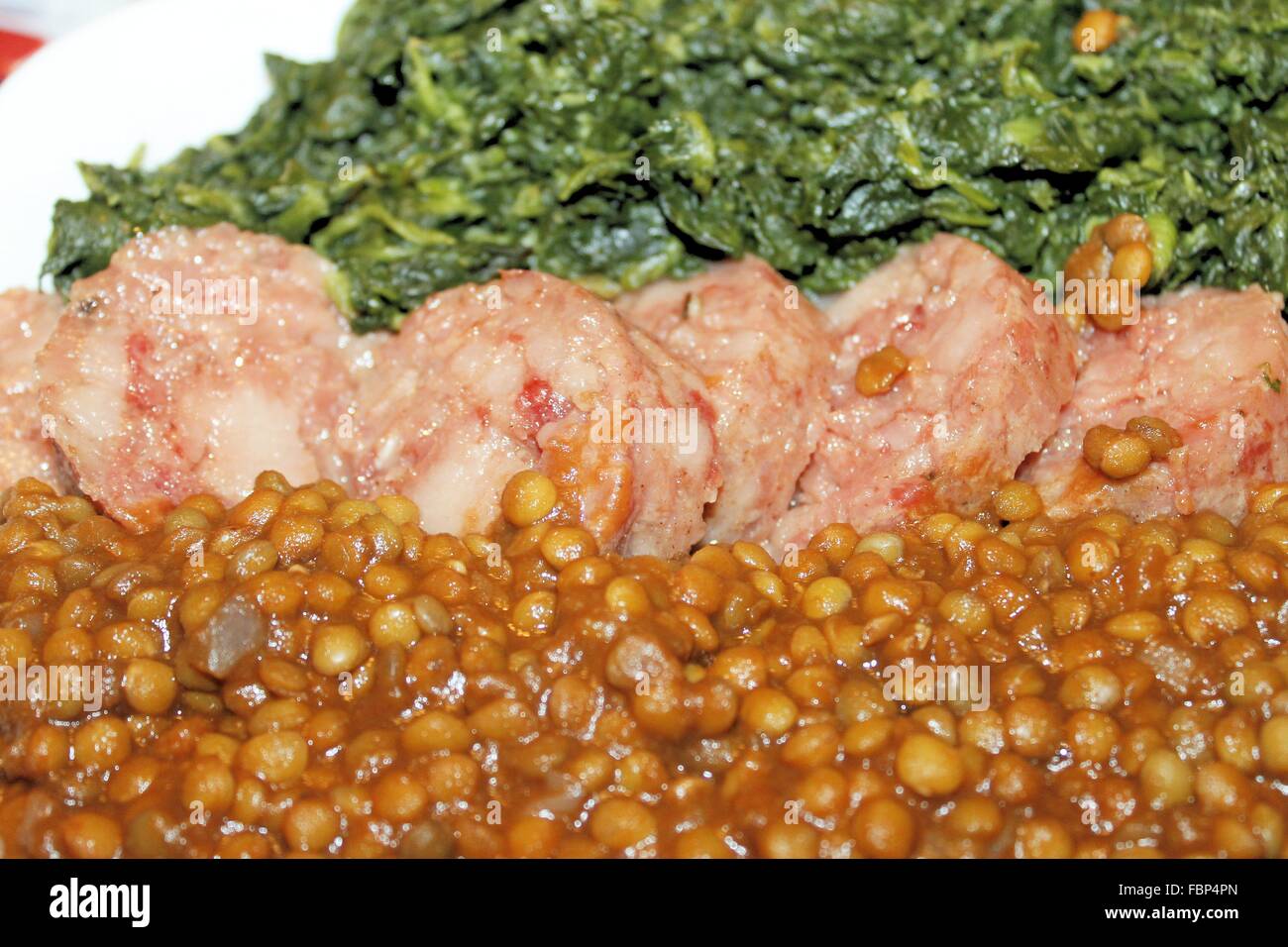Piatto con spinaci lessati, salame cotto e lenticchie Foto Stock