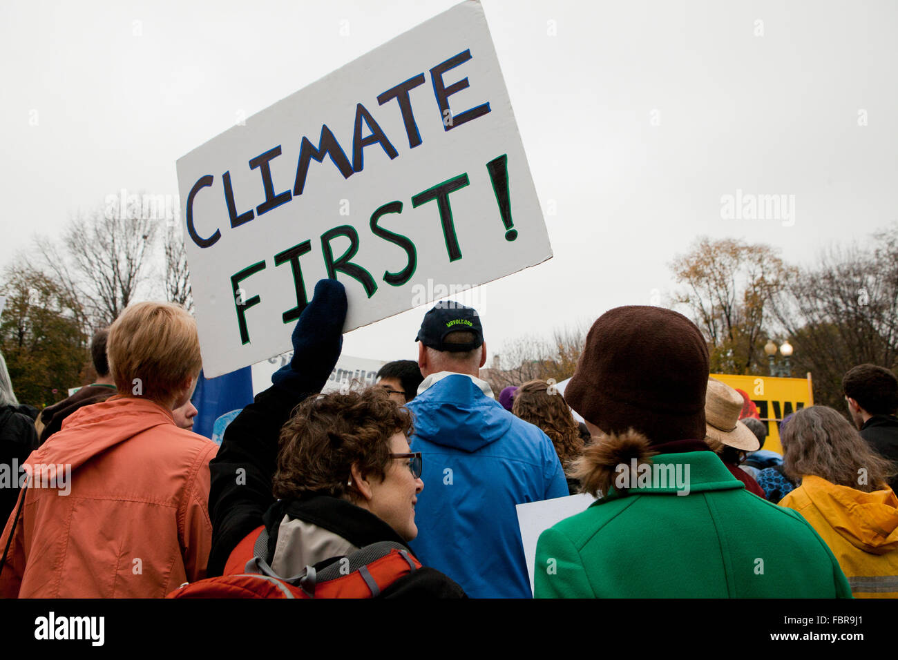 Novembre 21, 2015, Washington DC USA: attivisti ambientali protesta di fronte alla Casa Bianca (donna tenendo premuto 'clima primo segno) Foto Stock
