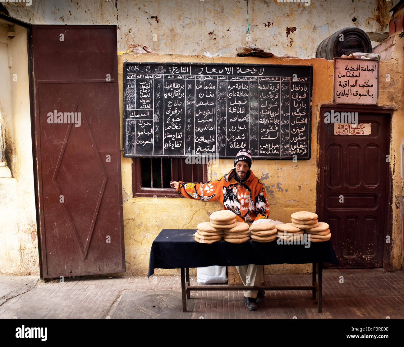 L'uomo vendere tipico pane arabo (flatbread) in una panetteria tradizionale in un mercato del Marocco. Meknes, Marocco. Foto Stock