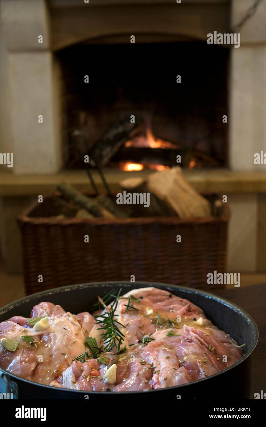 Haunch di maialino alla marinata in una casseruola davanti al caminetto Foto Stock