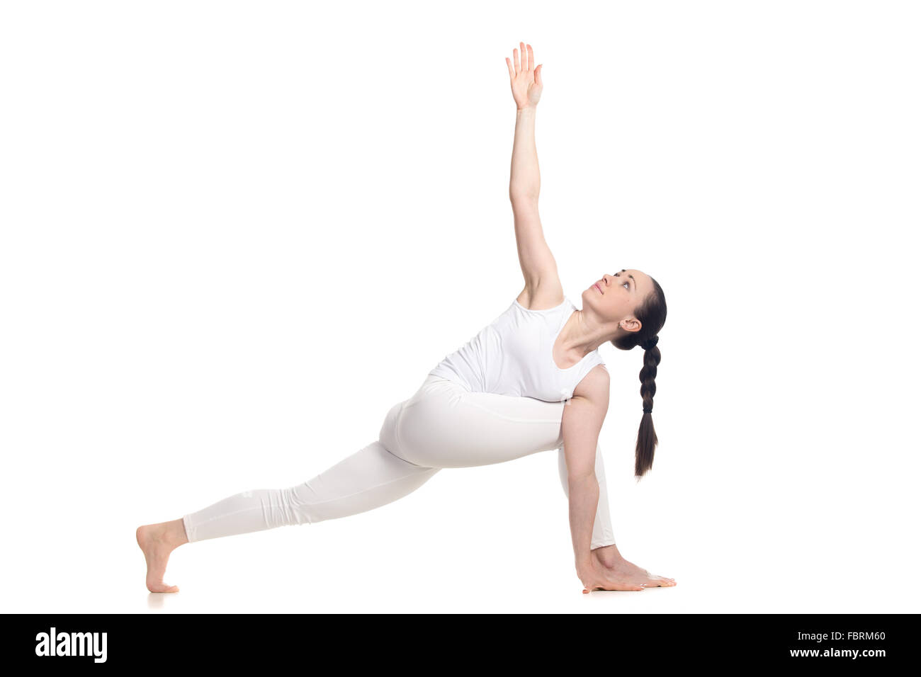 Sporty bella giovane donna in bianco sportswear con graziosi treccia affondo facendo esercizio per la flessibilità della colonna vertebrale Foto Stock