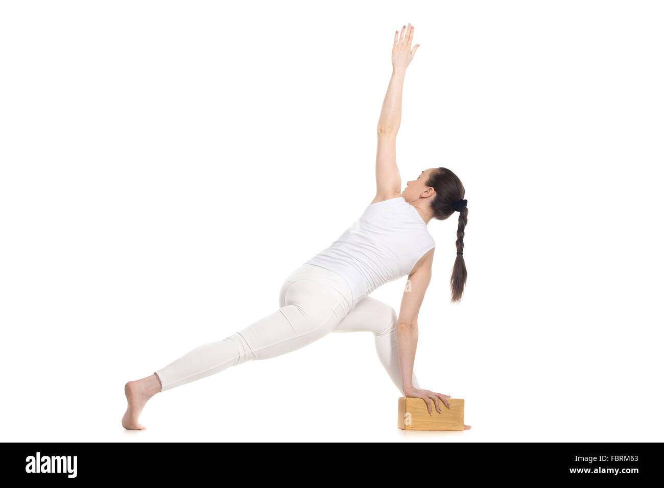 Sporty giovane e bella inizio yoga studentessa in bianco sportswear in piedi la semplice variazione del parivrtta parshvakonasana Foto Stock