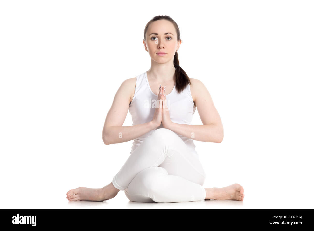 Sporty bella giovane donna seduta in Gomukhasana, Cowface pongono (yin yoga postura passalacci), asana per lo stiro di hips Foto Stock