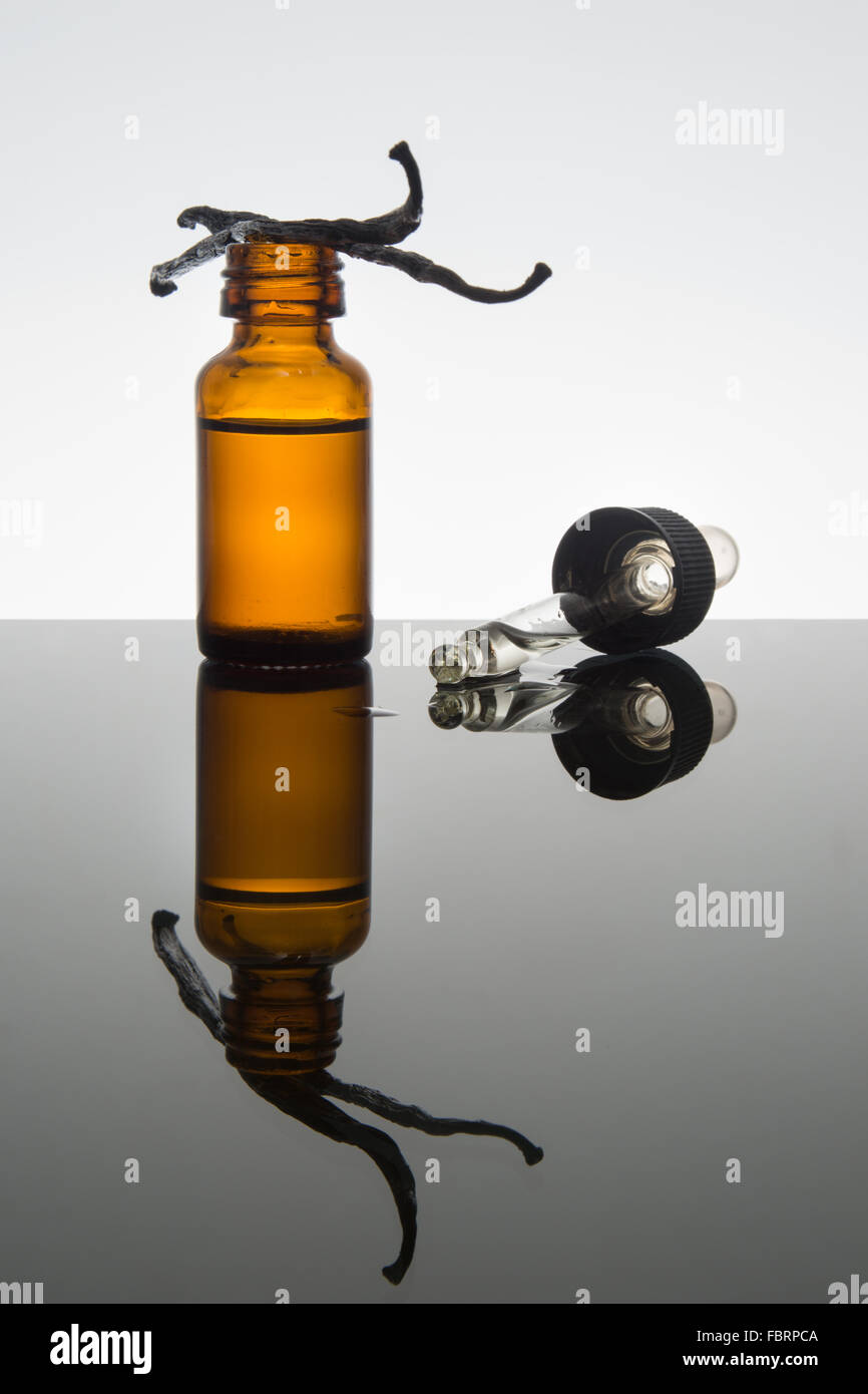 La vaniglia olio essenziale nel flacone color ambra con baccelli di vaniglia con contagocce Foto Stock