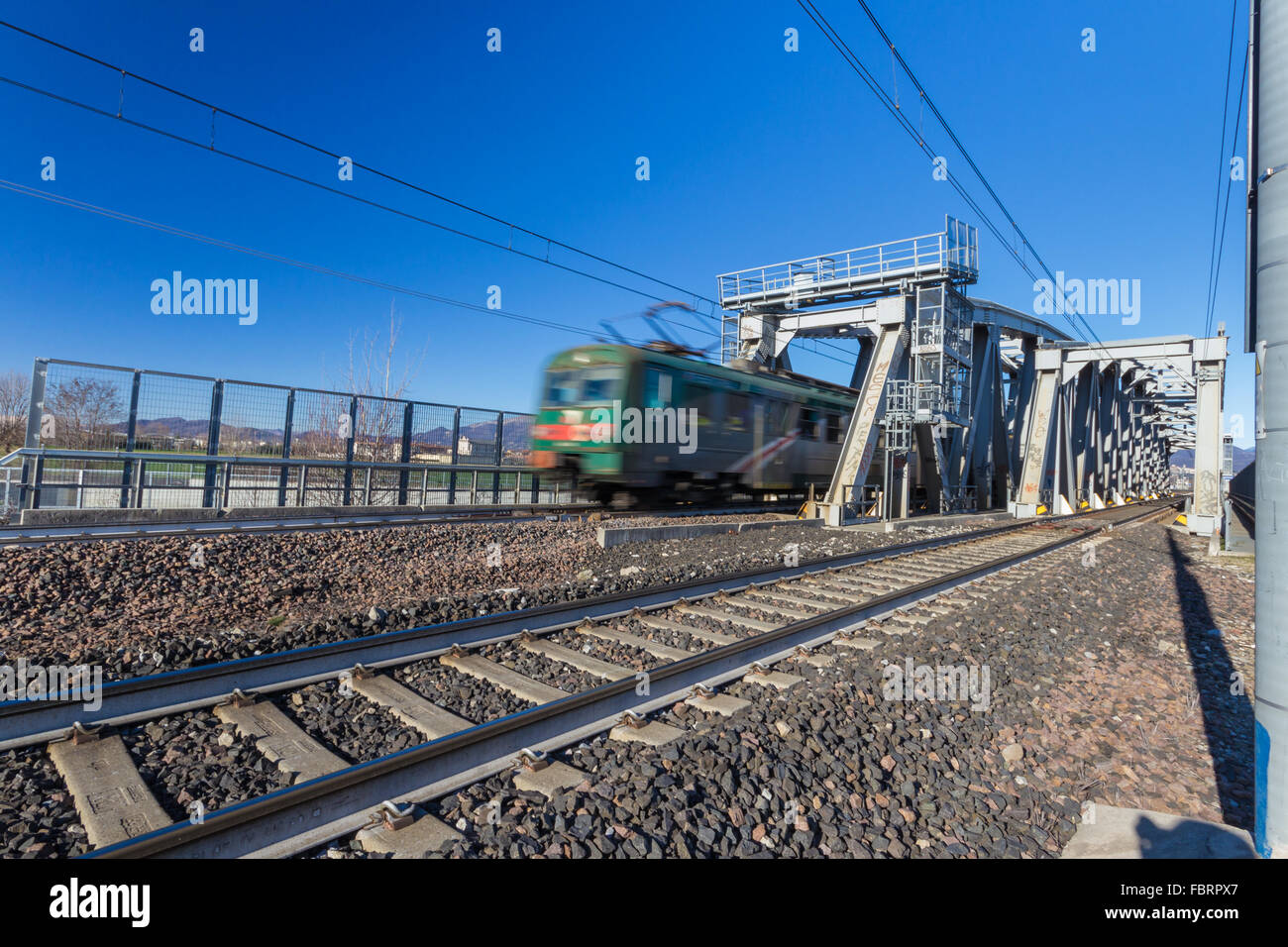 Ampio angolo di visione di un ponte ferroviario con treno passare Foto Stock