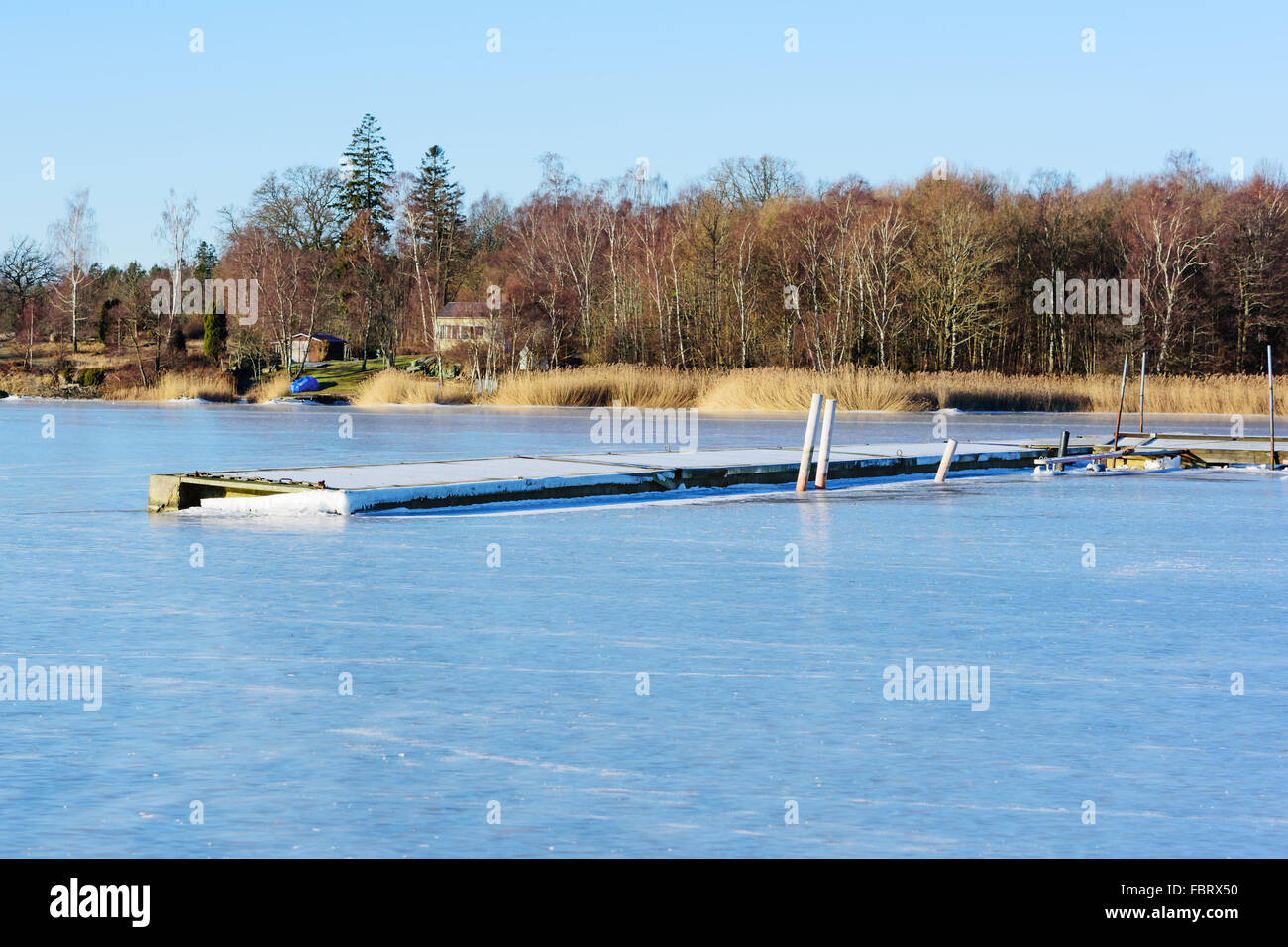 Paesaggio invernale o seascape con galleggiante ponte solido congelato nel mare di ghiaccio. Frost coprire il molo. Listerby, Svezia. Foto Stock
