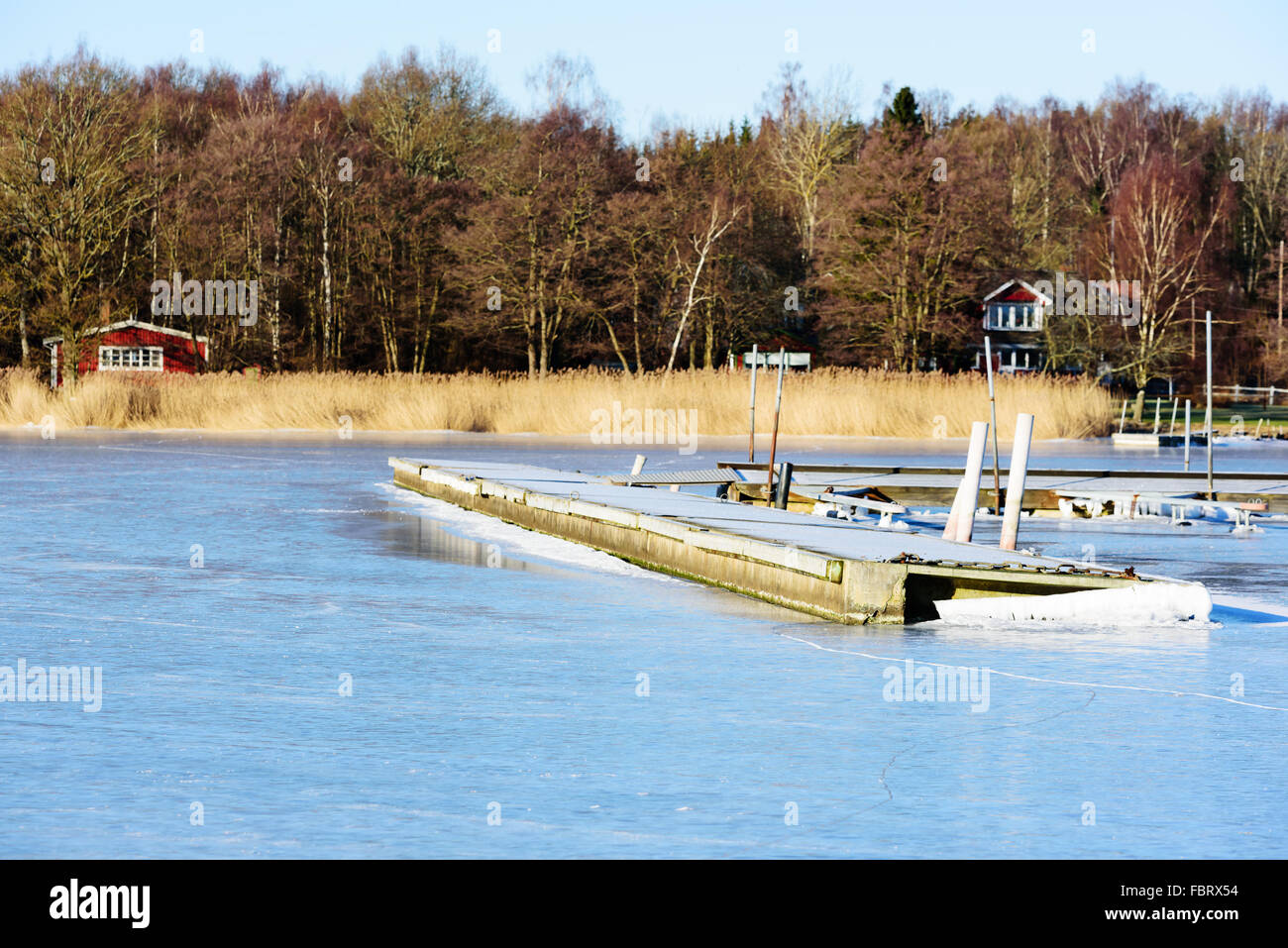 Paesaggio invernale o seascape con galleggiante ponte solido congelato nel mare di ghiaccio. Frost coprire il molo. Listerby, Svezia. Foto Stock