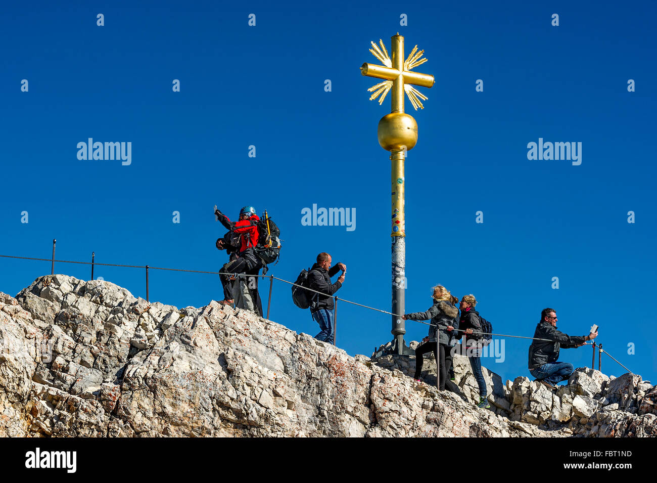 I turisti rendendo selfies e foto, vertice di croce sulla Zugspitze, Garmisch-Partenkirchen distretto, Wetterstein Alpi, Foto Stock