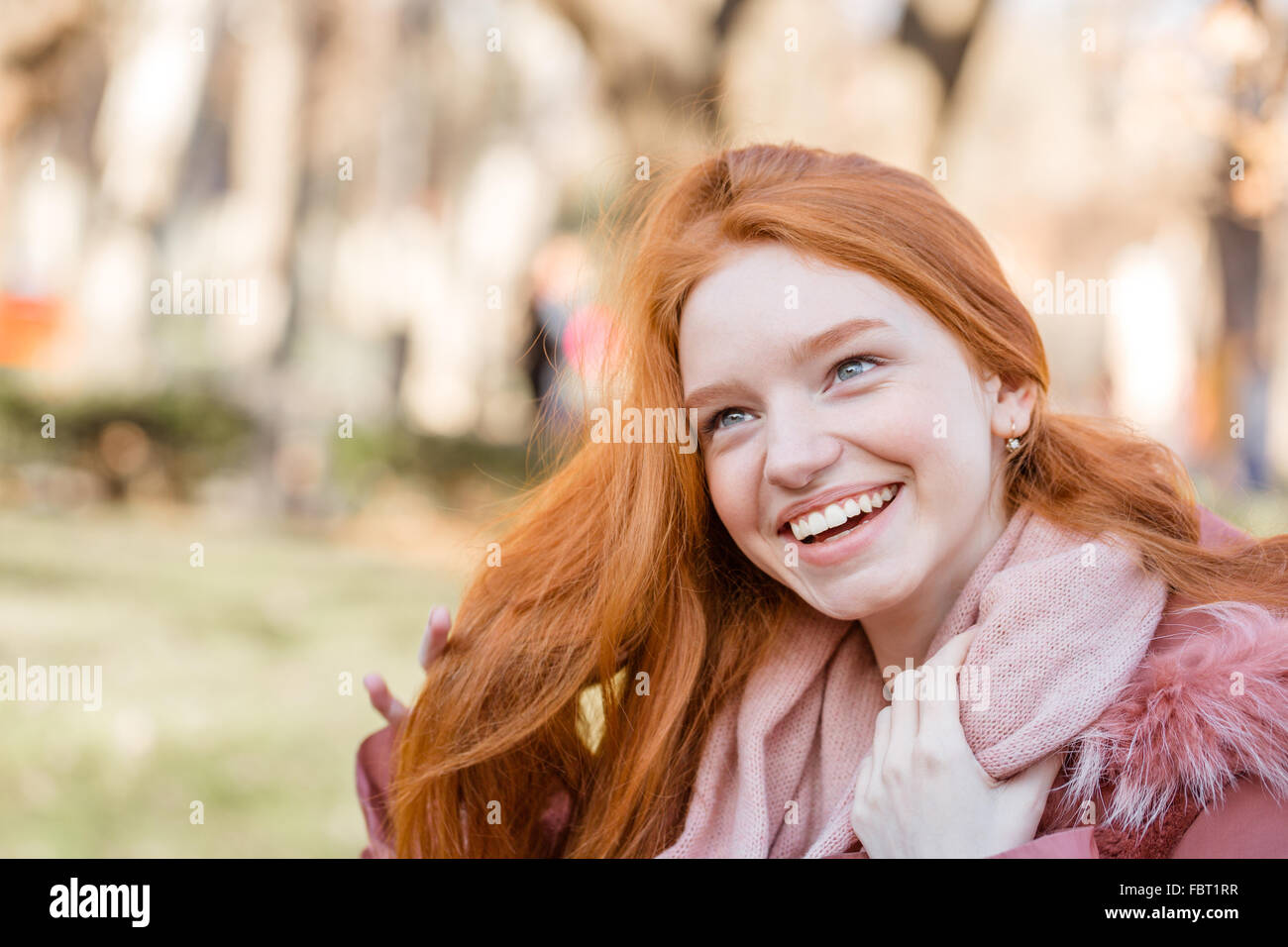 Ritratto di una giovane donna redhead ridendo all'aperto Foto Stock
