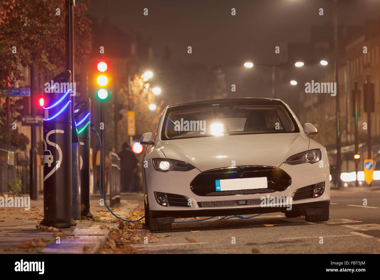 Tesla luxury auto elettrica in corrispondenza di un punto di ricarica in Kensington, Londra Foto Stock