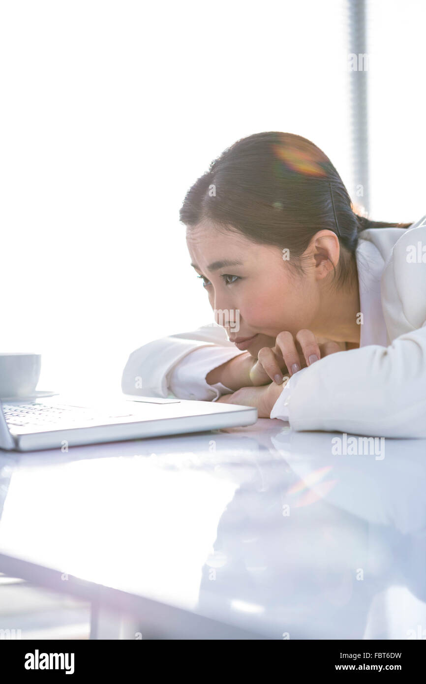 Grave donna appoggiata la sua mento sulle mani Foto Stock