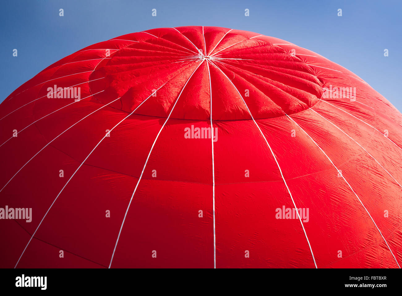 Tettoia rossa di aria calda palloncino gonfiato contro un luminoso cielo blu Foto Stock