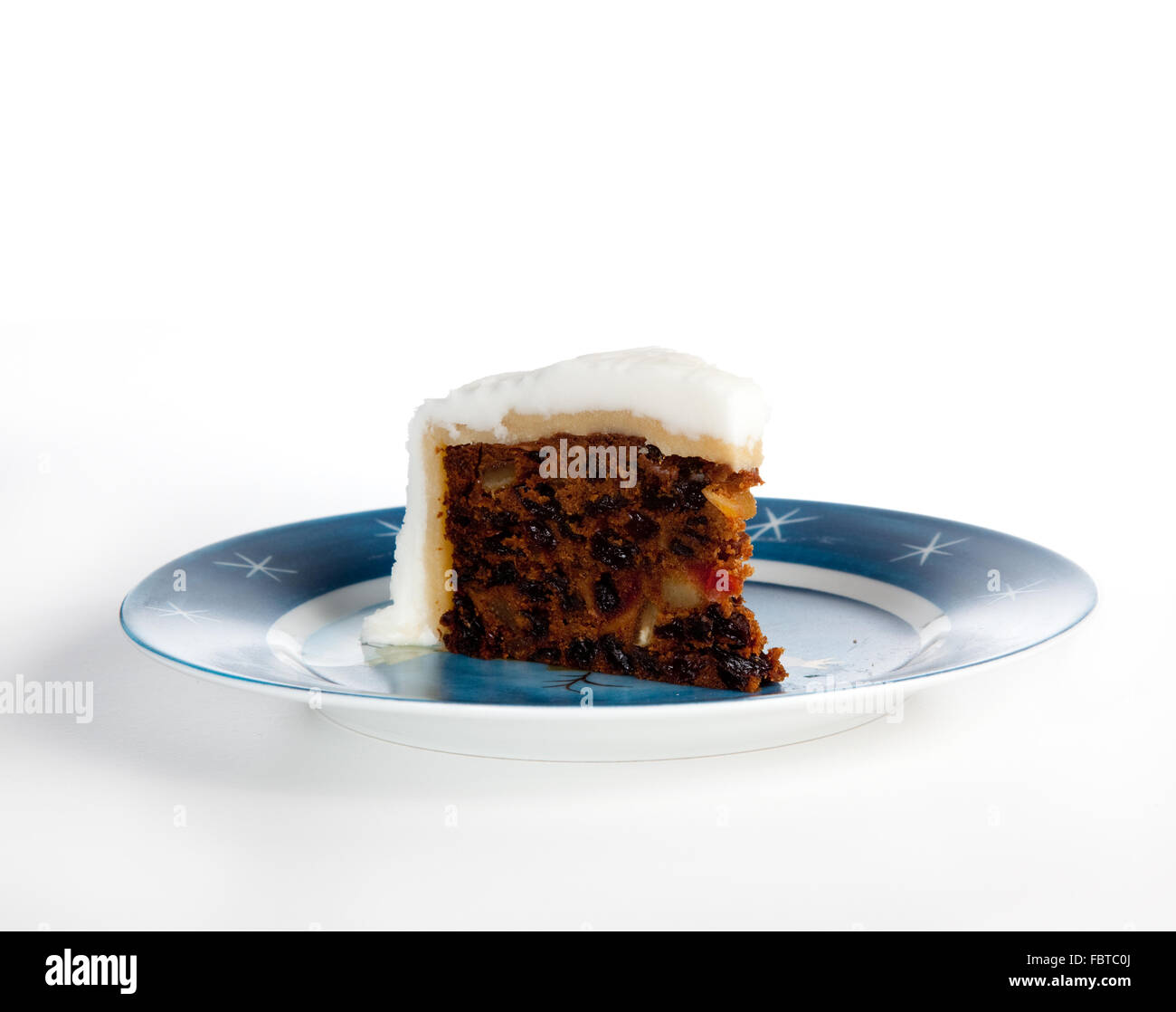 Sezione triangolare della tradizionale torta di natale su un blu piastra stellato Foto Stock