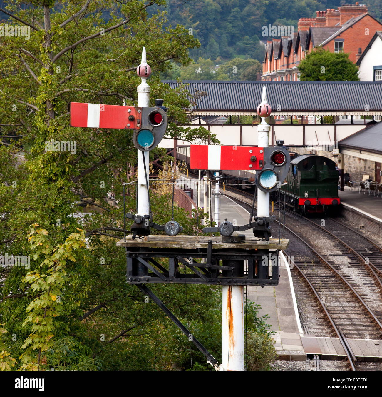 Vista della piattaforma della stazione a Llangollen in Galles incorniciato da segnali Foto Stock