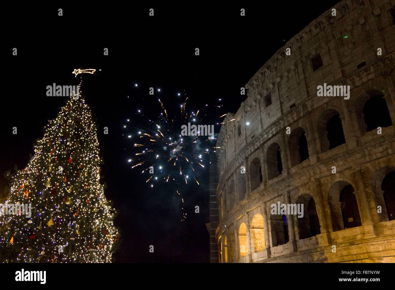 Roma, Italia - 1 gennaio 2015: Capodanno in Roma, fuochi d'artificio al Colosseo con un albero di Natale sul suo lato Foto Stock