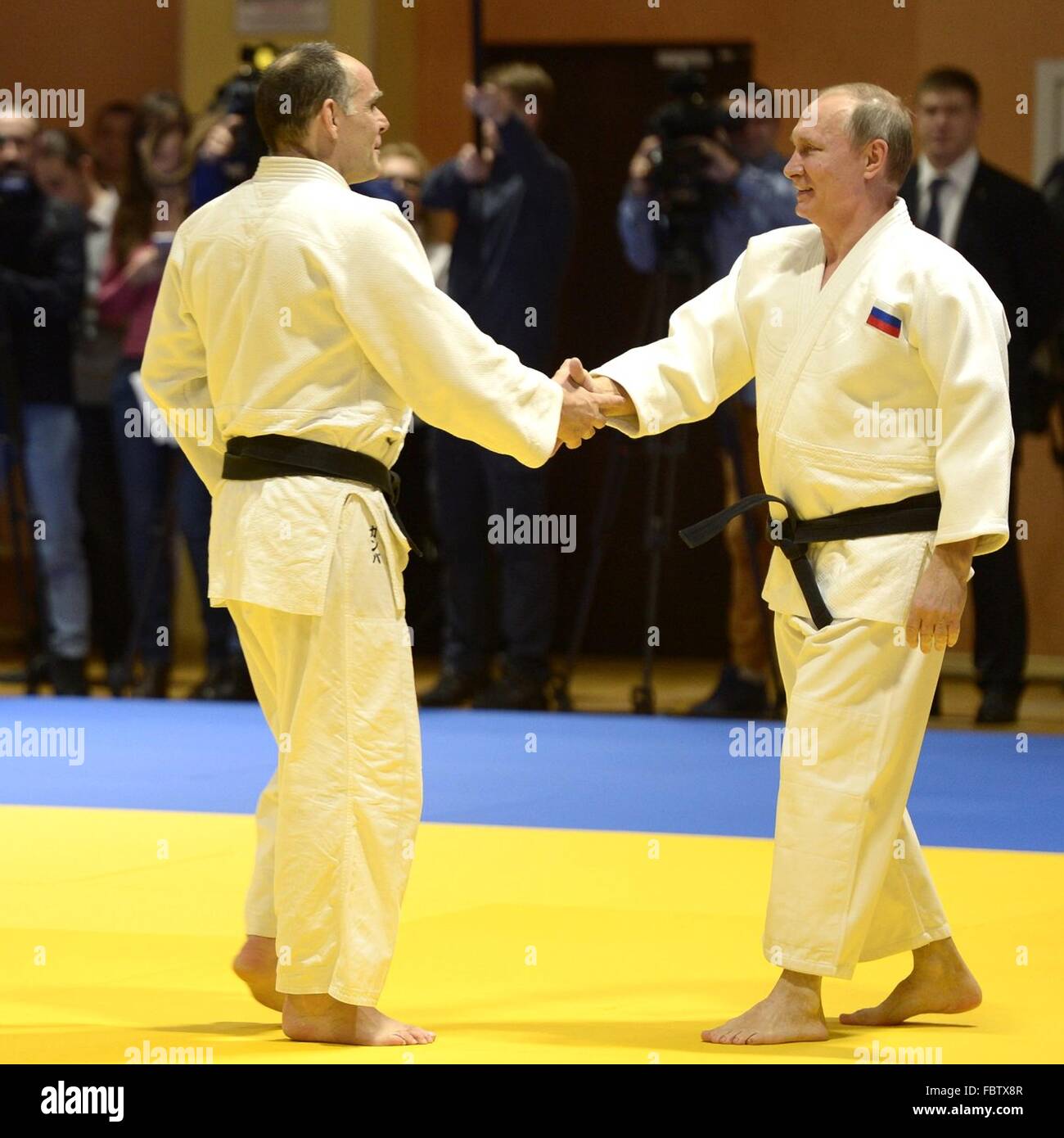 Il presidente russo Vladimir Putin scuote le mani con la federazione nazionale di judo allenatore della squadra di Ezio gamba prima di una sessione di sparing Gennaio 8, 2016 in Sochi, Russia. Foto Stock