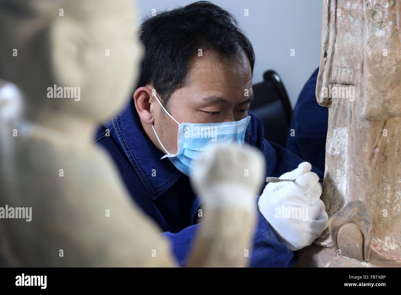 Dunhuang, la Cina della provincia di Gansu. Xix gen, 2016. Un technicist ripristina una ceramica dipinta figurina raccolti da Dunhuang Museum di Dunhuang, a nord-ovest della Cina di Provincia di Gansu, Gennaio 19, 2016. Un reliquie culturali progetto di restauro di ceramica dipinta oggetti storici sono iniziate il 15 gennaio dalla ricerca di Dunhuang Academy. © Zhang Xiaoliang/Xinhua/Alamy Live News Foto Stock