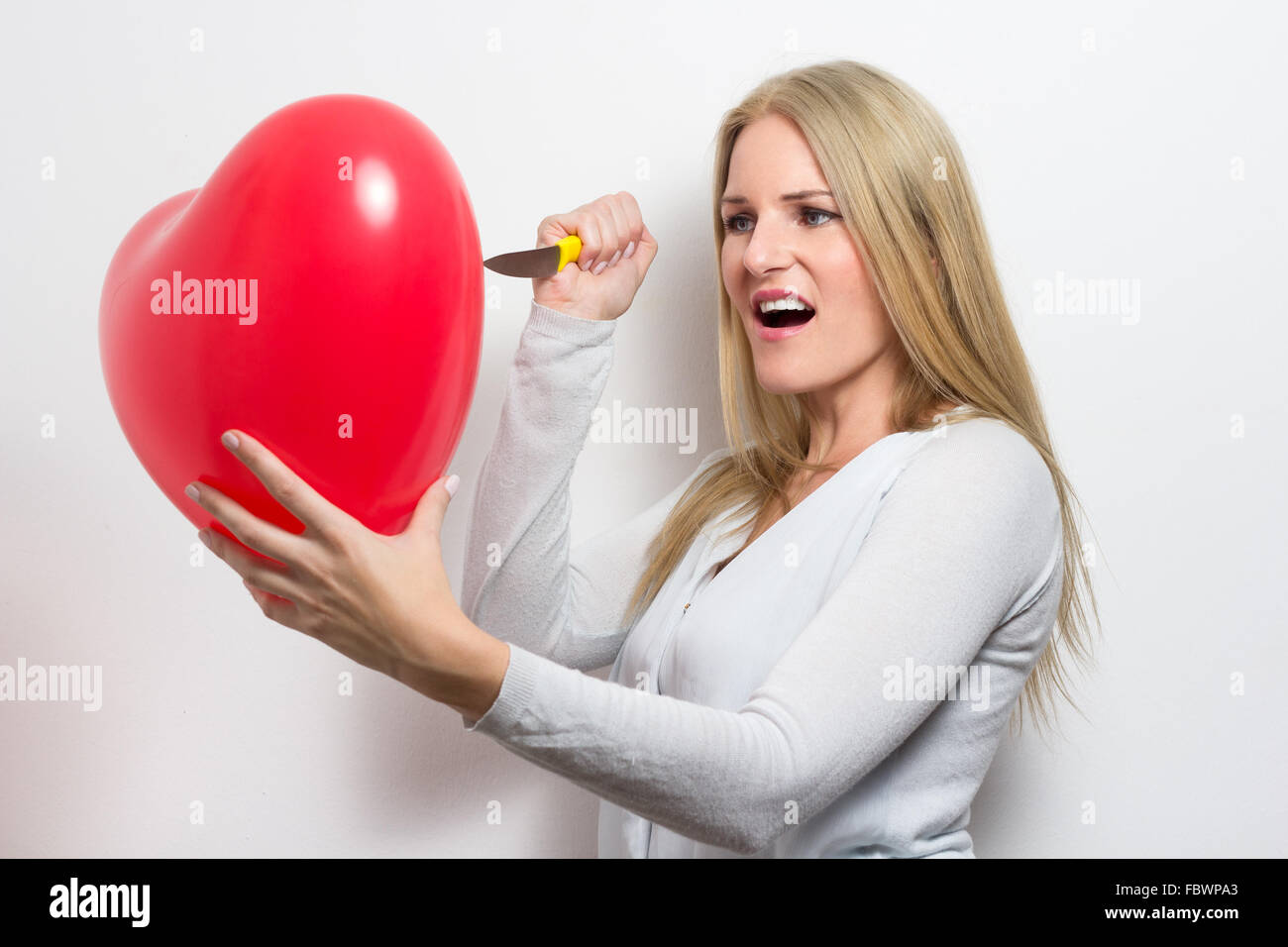 Donna distruggendo cuore dopo la rottura Foto Stock