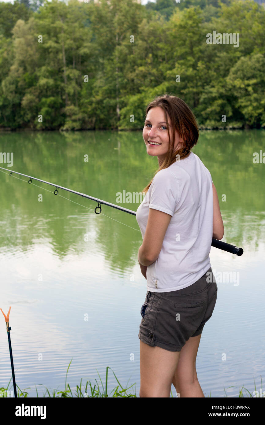 Donna di pesca in un lago Foto Stock