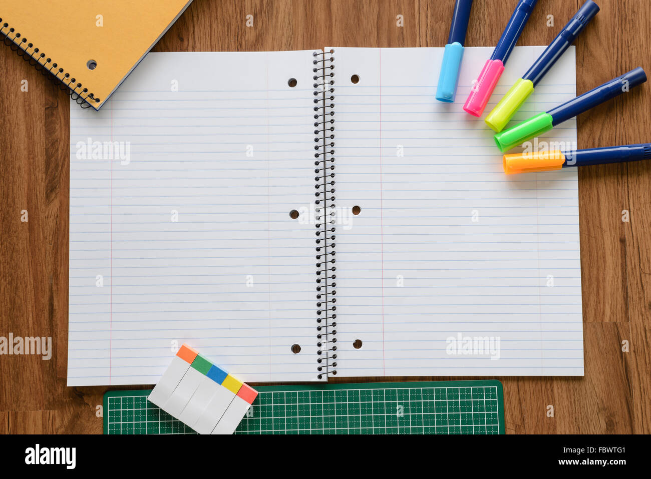 Colpo di overhead del notebook bianco uguale spaziatura linea sul pianale in legno Foto Stock