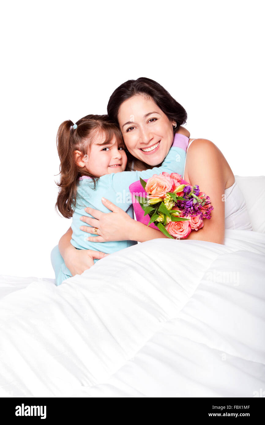 Bambino dà ai fiori di madre a letto Foto Stock