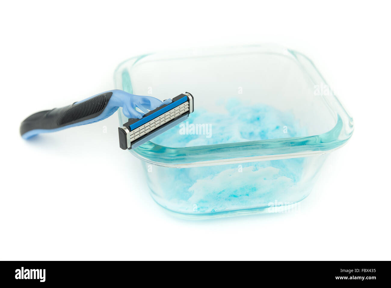 Triple le lame di rasoio per uomo la rasatura sulla pelle chiara del contenitore di vetro blu e di gel di rasatura, schiuma, isolare lo sfondo Foto Stock
