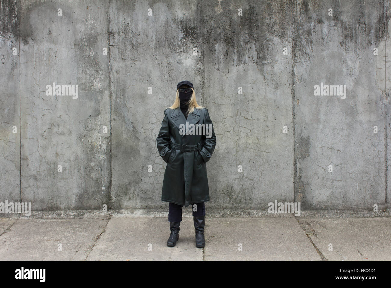 Masked donna bionda in cappotto di pelle Foto Stock