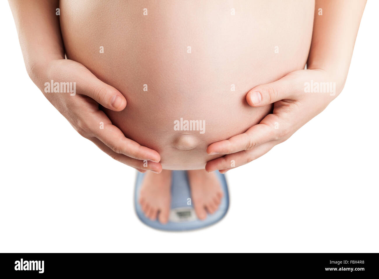 Donna incinta in piedi sul bilanciamento del peso Foto Stock