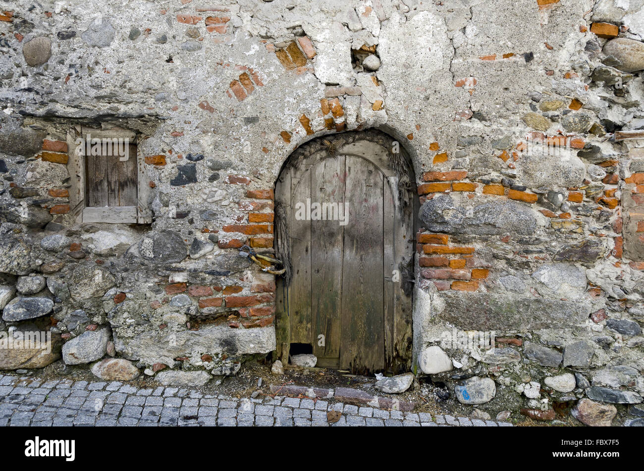 La vecchia porta in un vecchio muro Foto Stock