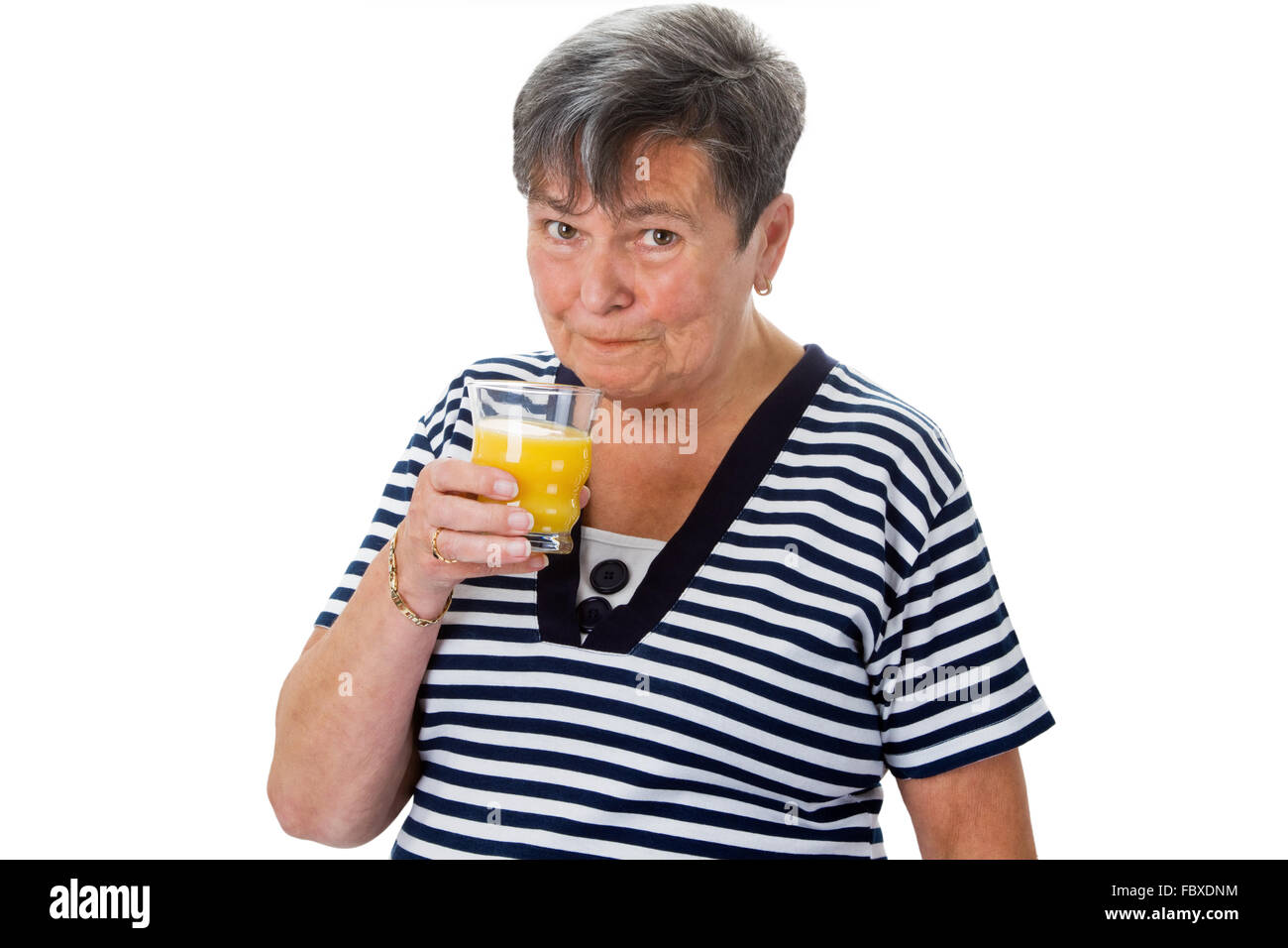 Donna anziana di bere succo di arancia Foto Stock