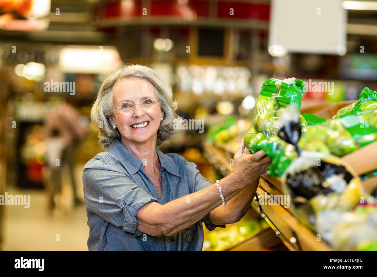 Senior donna felice sacco di contenimento di insalata Foto Stock