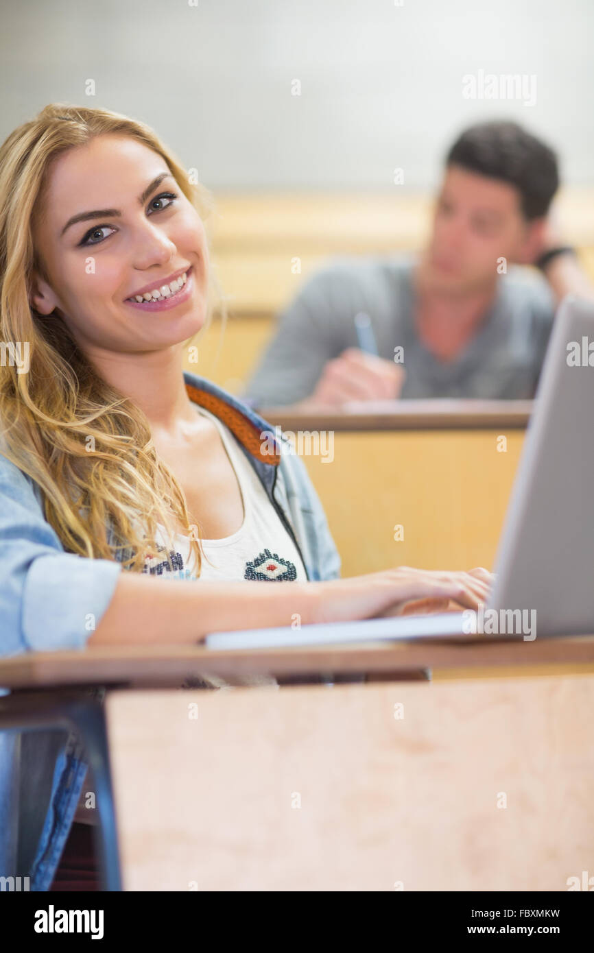 Sorridente attraente studente utilizzando laptop Foto Stock