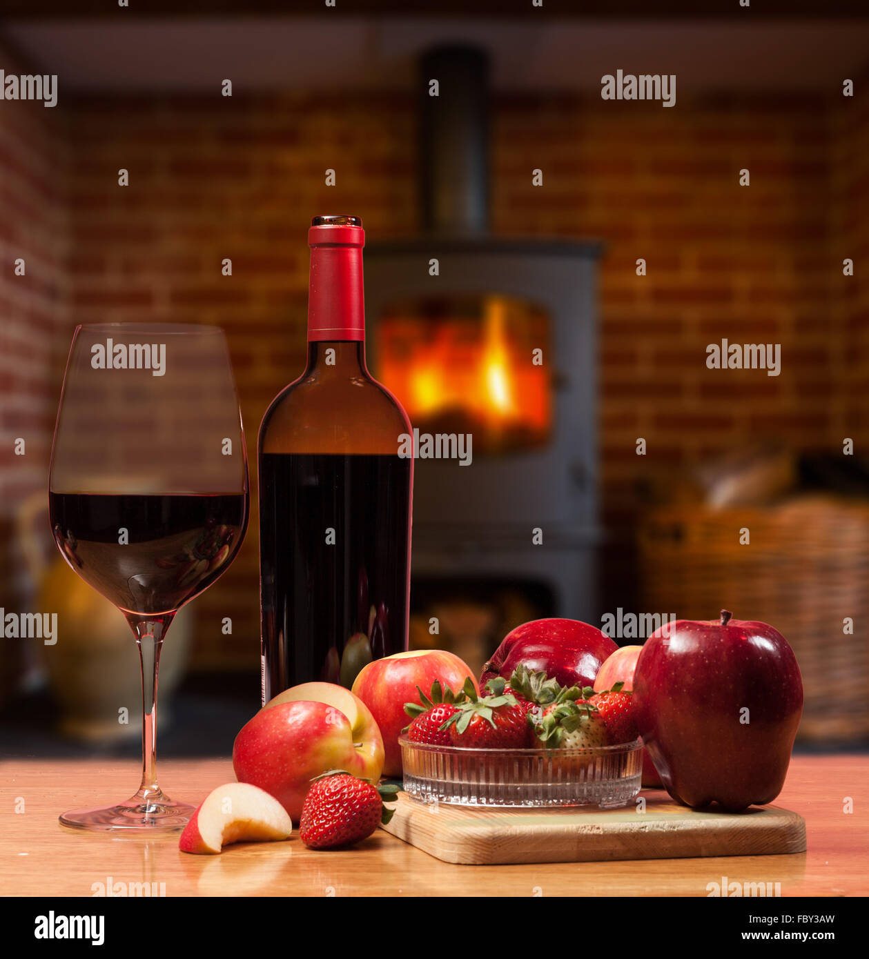 Vino rosso e frutta nella parte anteriore del fuoco ardente Foto Stock