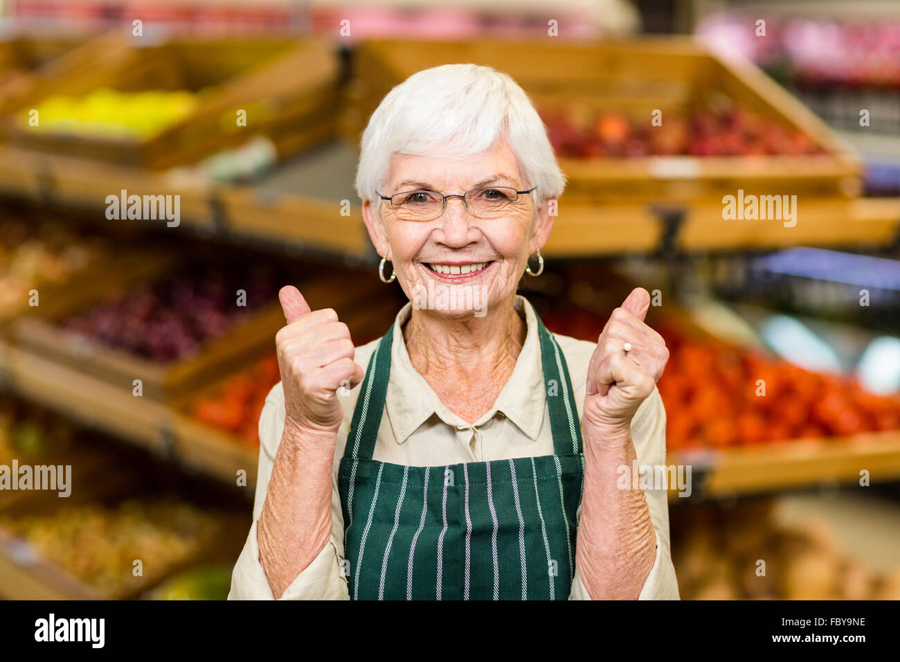 Senior lavoratore di sesso femminile con il pollice in alto Foto Stock