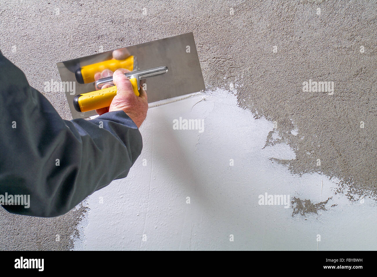 Operaio edile - Intonacatura e lisciatura della parete di calcestruzzo con  cemento bianco da una cazzuola in acciaio - si allinea a spatola Foto stock  - Alamy