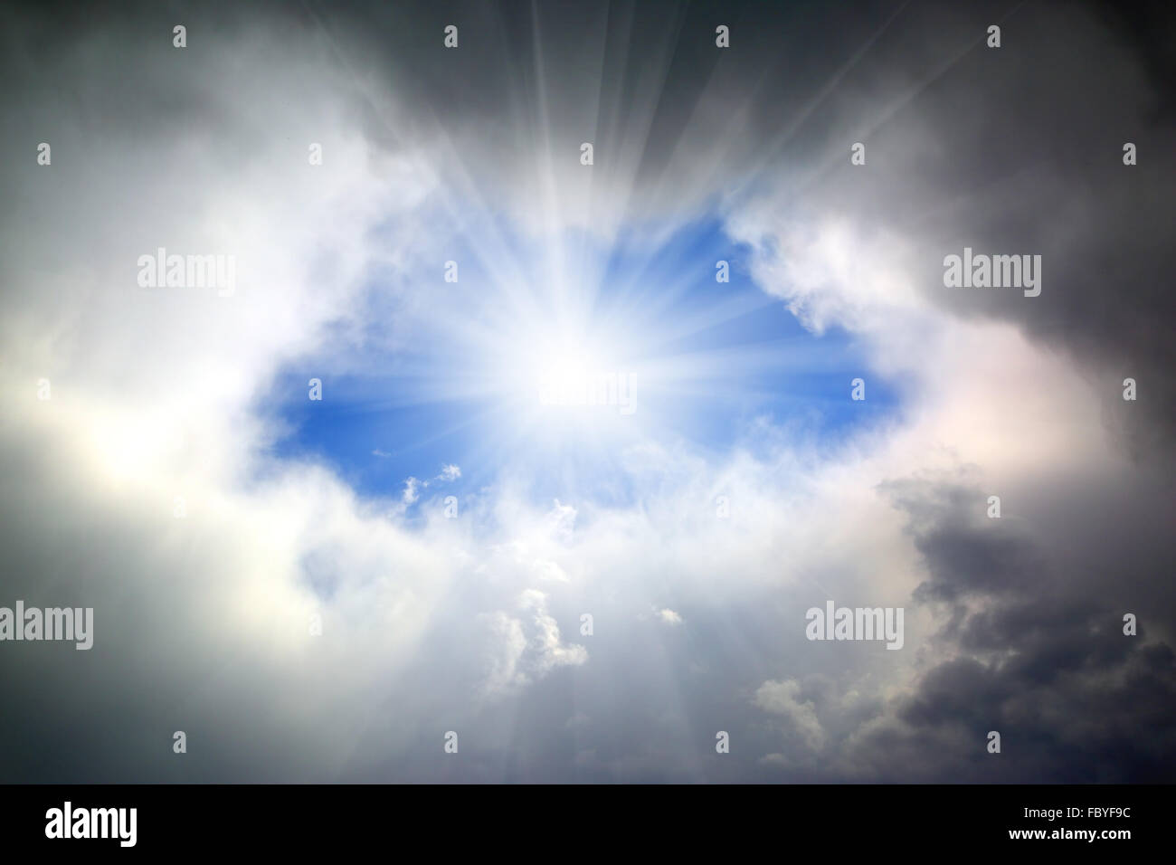Sole che splende attraverso il foro in nubi Foto Stock